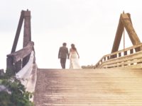man-and-woman-holding-hands-while-walking-on-bridge-1048029